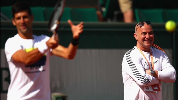 Andre Agassi looks on as Novak Djokovic goes through his warm-up
