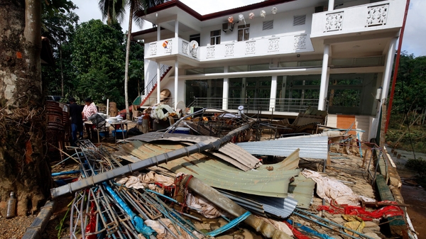A family cleans their home in the flood affected area of Bulathsinhala