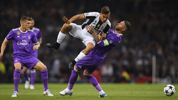 Paulo Dybala of Juventus and Sergio Ramos of Real Madrid battle for possession