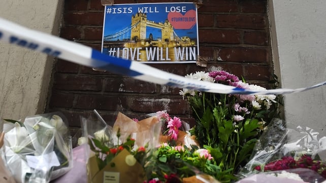 Floral tributes are seen below an anti ISIS poster seen near Borough Market, in the aftermath of the London attacks