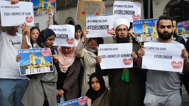 Members of London's Muslim community hold signs of condolence and support near the site of the attack at Borough Market