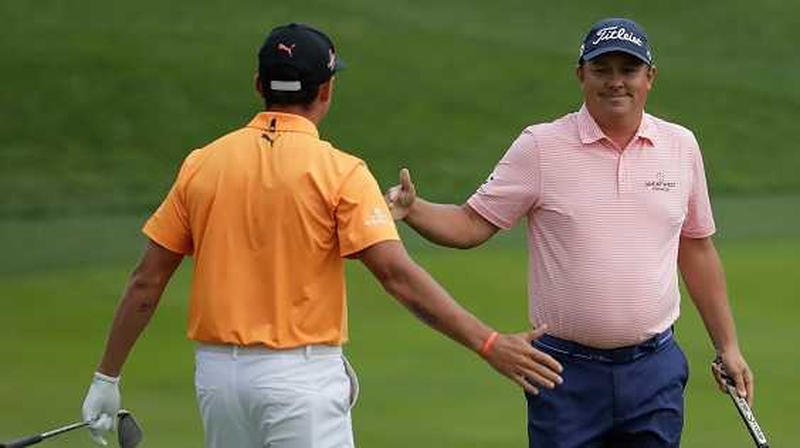 Jason Dufner is congratulated by Rickie Fowler on the last green