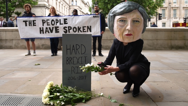 A protester wearing a Theresa May mask in London this morning