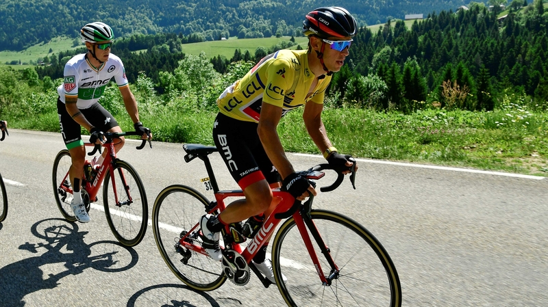 Australia's Richie Porte (R), wearing the overall leader's yellow jersey, leads out from his teammate Nicolas Roche of Ireland