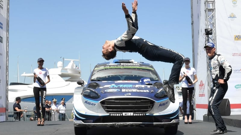 Estonian driver Ott Tanak (R) looks at his co-driver Martin Jarveoia of Ford Fiesta RS WRC celebrating in style