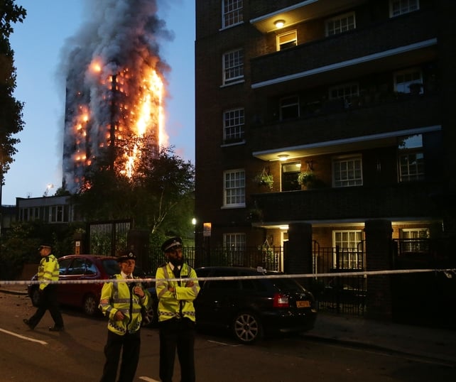 Police officers in position at the edge of a cordoned-off area around Grenfell Tower