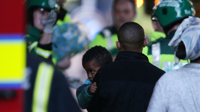 A child is brought to an ambulance inside the security cordon