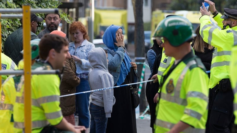 Local residents and emergency personnel at the cordon set up around the area