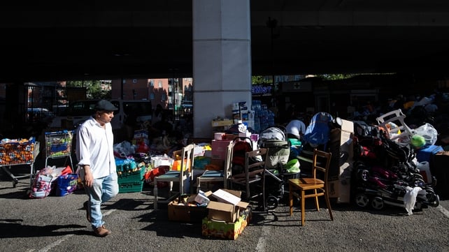A man walks by the Westway Sports Centre where donations for the victims of the Grenfell Tower fire build up