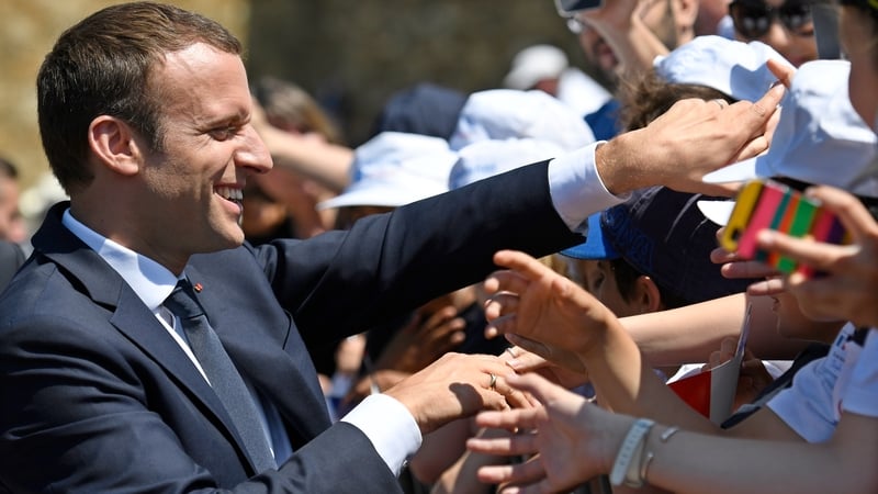 French President Emmanuel Macron shakes hands with people during a World War Two ceremony in Paris this afternoon