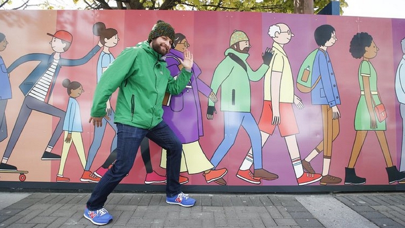 Illustrator Chris Judge pictured with his new mural for Dublin's Dockland's area.