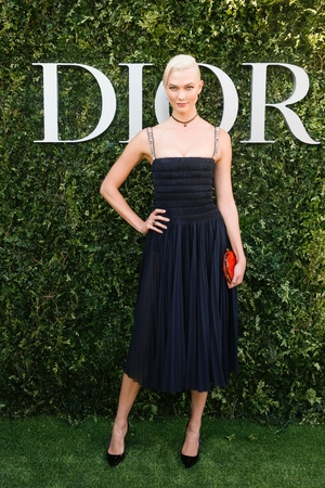 Model and dancer Karlie Kloss made a splash with platinum blonde hair and a strappy black cocktail dress from Dior's SS17 line.
