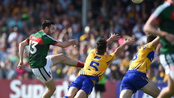 Mayo's Kevin McLoughlin scores a point despite the block attempt from Cian O'Dea of Clare