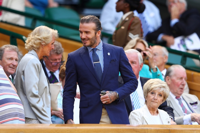 David Beckham looked smart wearing a navy sport coat from Ralph Lauren paired with a striped blue shirt, blue knit tie and gold tie clip.