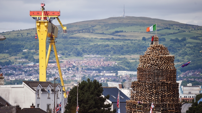 A tricolour flies from an unlit bonfire in Belfast