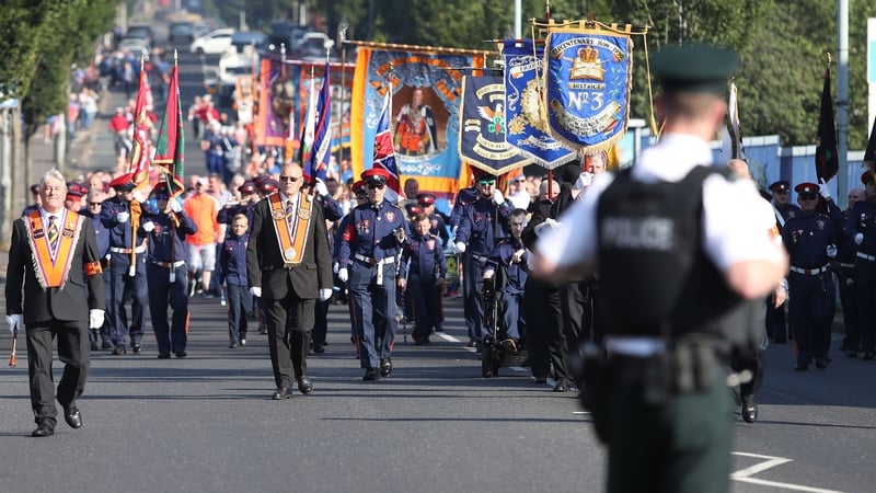 The Orange Order parade make its way past the nationalist Ardoyne area this morning