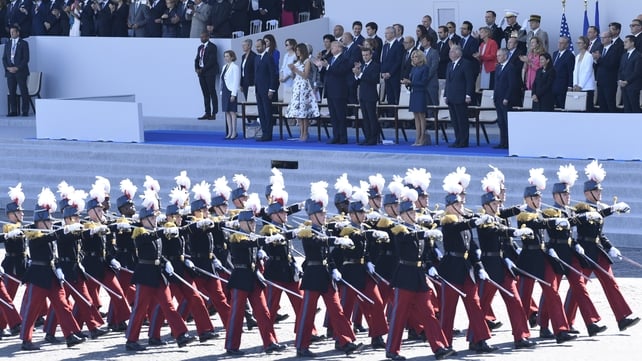 Members of the military walk past dignitaries, including US President Donald Trump