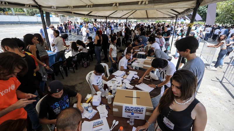 People wait to vote in the unofficial referendum in Caracas, Venezuela