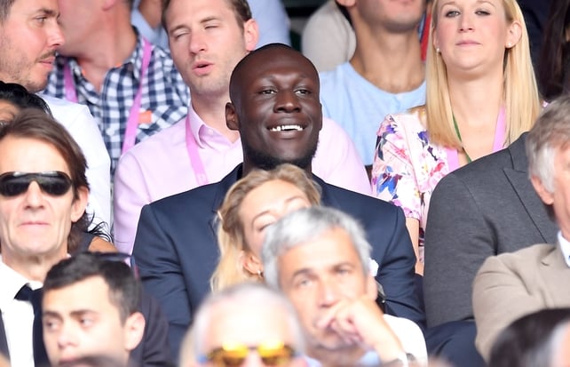 Stormzy looks smart in a grey suit while attending Wimbledon.