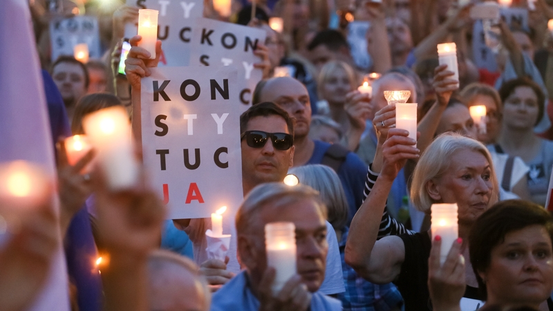 People holding candles participate in a protest in front of the Supreme Court building in Warsaw