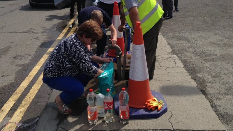 Members of the public queue up at a temporary water station in Drogheda