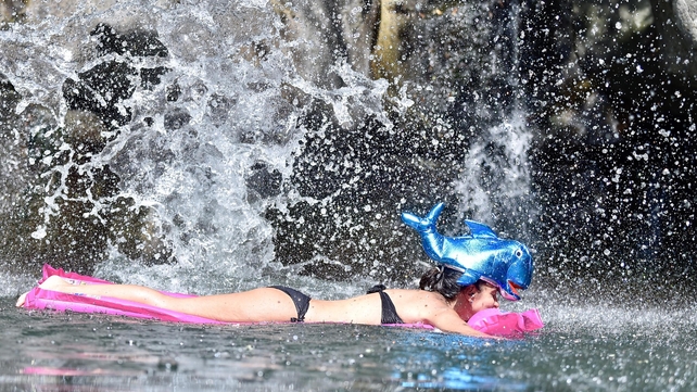 A woman swims on an air bed in Ciuffenna river during in, Arezzo, Italy