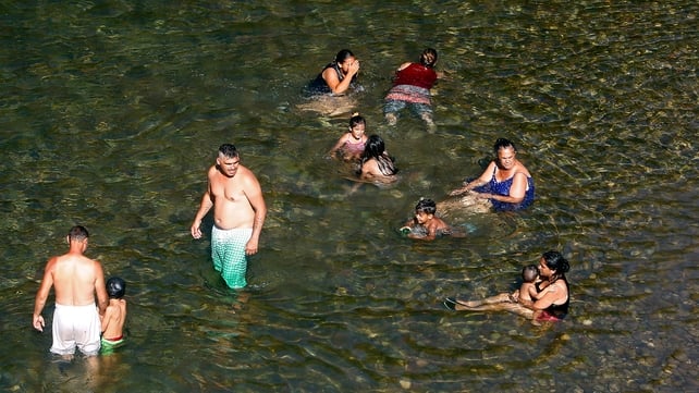 People cool themselves in the waters of the river Nisava, on the outskirts of Nis, Serbia, yesterday