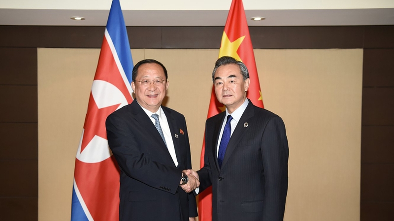 China's Foreign Minister Wang Yi (R) shakes hands with North Korea's Foreign Minister Ri Yong Ho (L) during their bilateral meeting