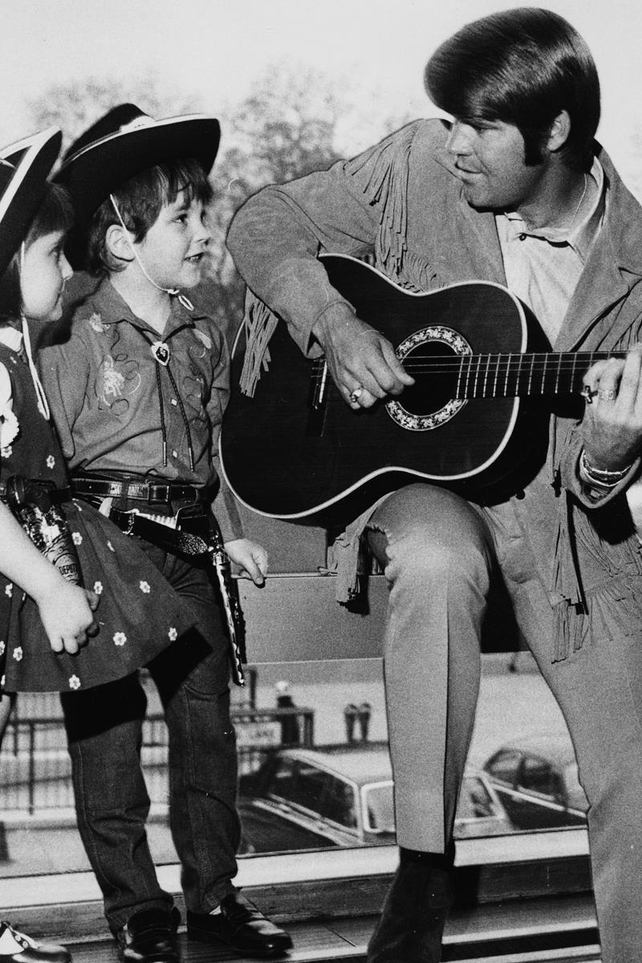 Glen Campbell playing the guitar for two young fans, 1970.