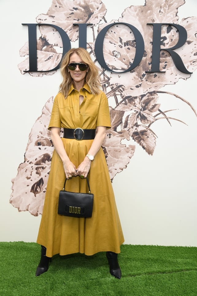 Celine Dion attended the Christian Dior Haute Couture 2017/18 show at Paris Fashion Week wearing a Dior yellow leather shirt dress with wide buckle belt and Dior handbag.