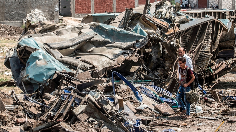 An Egyptian man and a boy look at the wreckage in Alexandria today