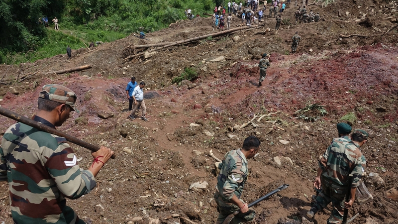 Members of the Indian Army and rescue teams search the site in Mandi, Himachal Pradesh, India