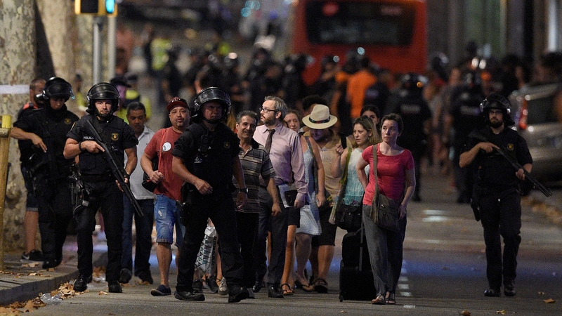 Security forces lead people away from a cordoned off area in Las Ramblas