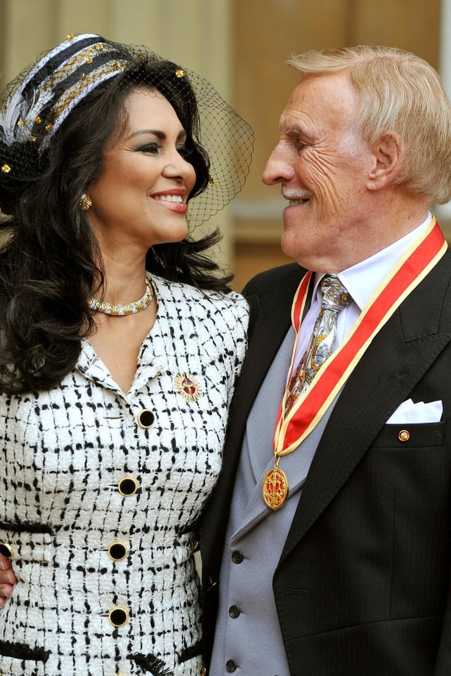 Bruce Forsyth and his wife Wilnelia pose after he was knighted by Britain's Queen Elizabeth II at Buckingham Palace on October 12, 2011