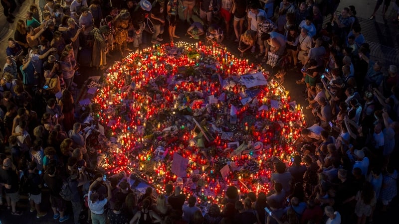 People pay tribute to victims outside the Liceu Theatre in Barcelona