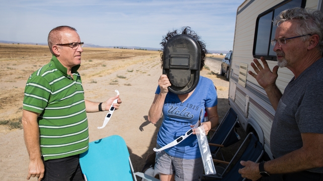Martin Ferreira (L) Michele Nemschoff (C) and Keith Petterson (R), total eclipse enthusiasts, try out their protective eye wear