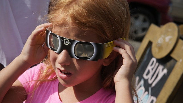 Zoe Spyridonos tries out eclipse glasses ahead of the total solar eclipse in Charleston, South Carolina