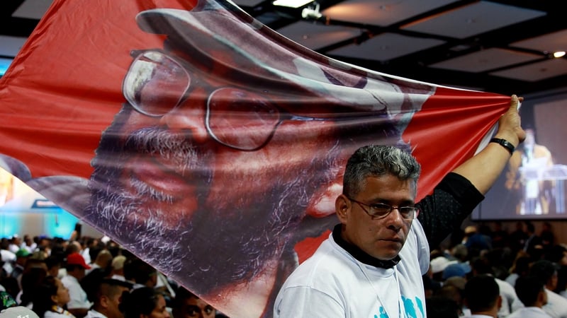 A man shows a flag with the picture of late FARC leader Guillermo Leon Saenz, during the National Congress