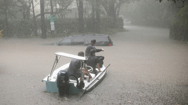 Search and rescue volunteers scour flooded neighbourhoods