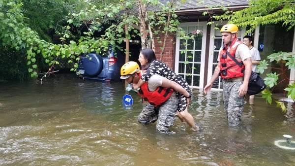 Texas National Guard help a woman our of her flooded home in Houston