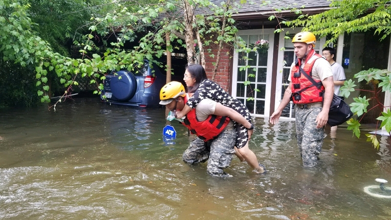 Texas National Guard help a woman our of her flooded home in Houston
