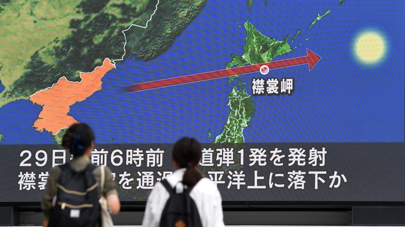 People watch a report on the strike on a screen in Tokyo