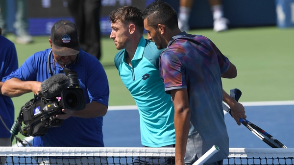 Compatriots Nick Kyrgios and John Millman embrace after the 14th seed crashes out