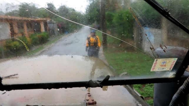 A search and rescue crew member directs a truck driver through a narrow road during a search mission as Hurricane Irma hits Puerto Rico