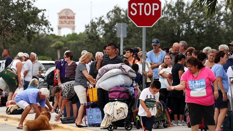 People wait in line to enter the Germain Arena that is serving as a shelter in Estero, Florida