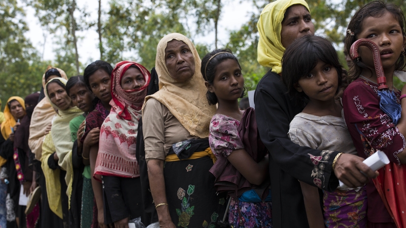 Rohingya refugee women queue for food rations after arriving from Myanmar on September 10, 2017 in Whaikhyang, Bangladesh