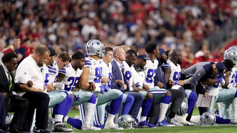 Members on the Dallas Cowboys kneel during the US national anthem