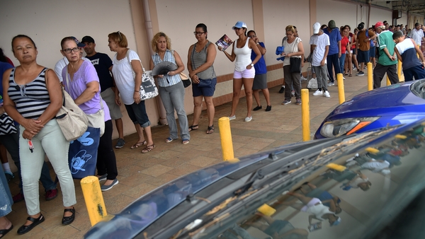 People queue to enter a supermarket