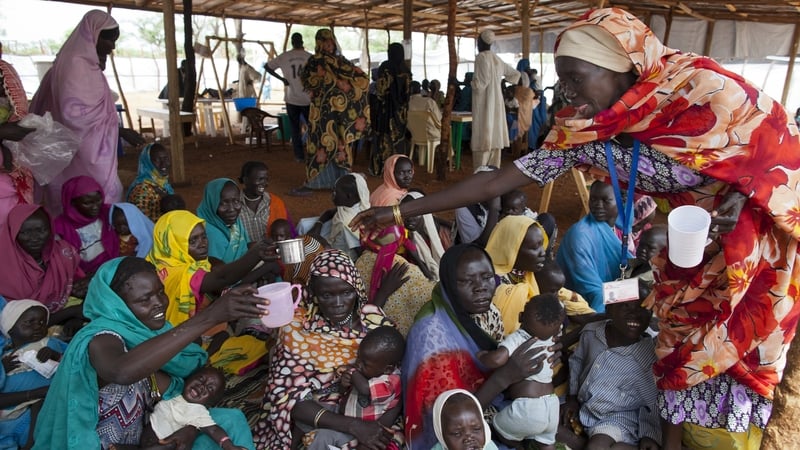 Sudanese mothers gather for a therapeutic feed for their malnourished babies