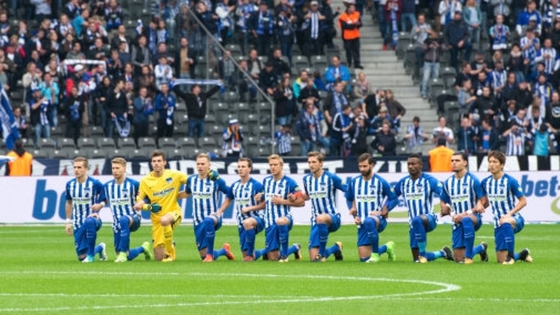Players from Hertha Berlin take a knee before a Bundesliga game.